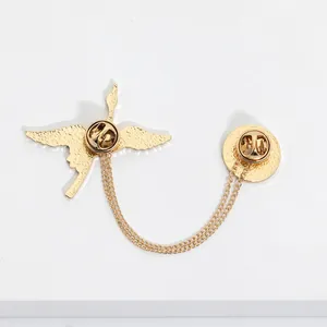 Detail of the golden crane brooch featuring double lapel pins and a layered chain design