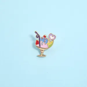 Detailed view of sundae enamel brooch with pink and purple glaze on light blue background