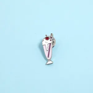 Detail of pink enamel milkshake brooch with white cream and a red cherry on top