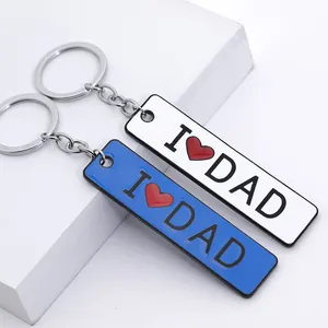 Macro detail of I Love Dad keychains in blue and white with red heart lacquer