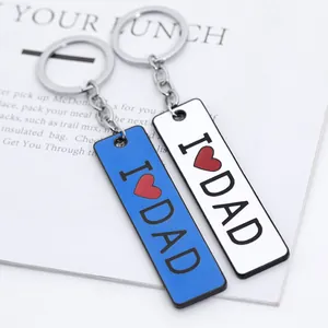 Close-up of blue and white rectangular keychains with red heart and I Love Dad engraving
