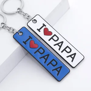 Close-up of rectangle metal keychains with I Heart PAPA print in white and blue colors