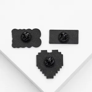 Detailed back view of black metal badges with anti-slip texture and secure rubber clasps
