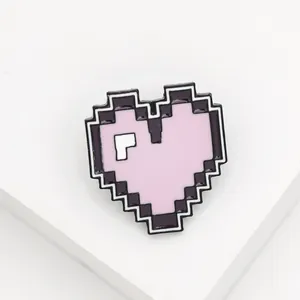 Detail of pixel art heart enamel pin in pink and purple on white geometric stand