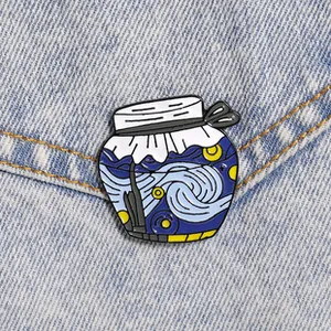 Close-up of Van Gogh Starry Night enamel pin on blue denim jacket fabric background