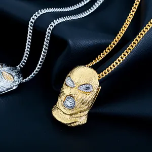 Détail de pendentifs cagoule hip-hop dorés et argentés avec yeux incrustés de strass brillants