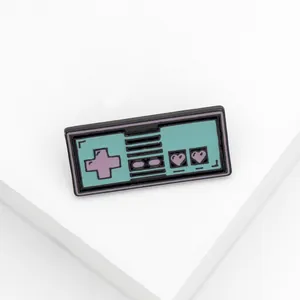Detailed view of mint green retro game controller enamel pin with purple heart buttons