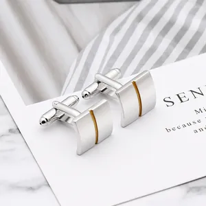 Polished silver square cufflinks with golden vertical lines shown on dress shirt