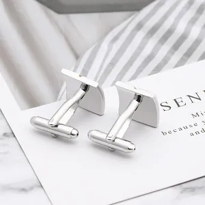 Detail shot of polished silver square cufflinks with classic T-shaped bullet back closure
