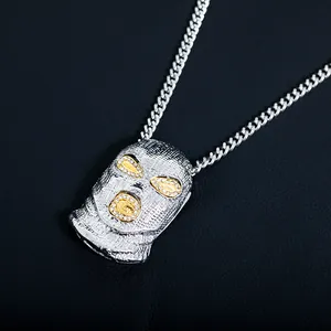 Gros plan du pendentif cagoule hip hop argenté avec détails dorés et strass brillants