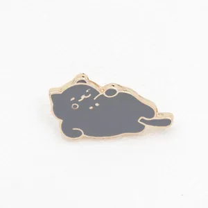 Detailed close-up of a cute cartoon gray cat enamel brooch with golden metal edges