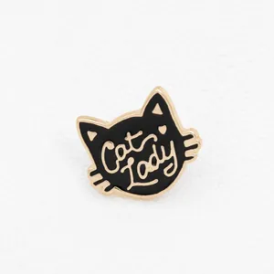 Close-up of black and gold enamel cat head pin featuring Cat Lady artistic lettering