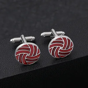 Detail of red enamel round cufflinks with silver sports stitching on black texture