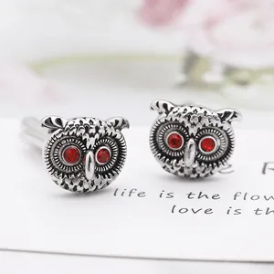 Boutons de manchette chouette argentés vintage avec yeux en gemme rouge sur carte