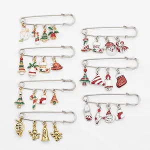 Detail view of seven Christmas enamel brooches with tree, snowman and bell charms