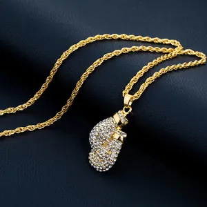 Macro view of iced out boxing glove pendant with white zircons on golden rope chain