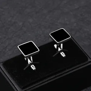 Makroaufnahme von silbernen Manschettenknöpfen mit schwarzem Emaille-Inlay