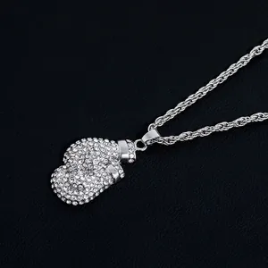 Macro shot of silver boxing glove pendant with iced-out cubic zirconia on rope chain