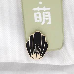 Macro detail of a fan-shaped black enamel flower brooch with golden metallic stamens