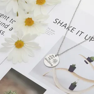 Détail du collier You Are My Sunshine sur un fond de marguerites et de magazine