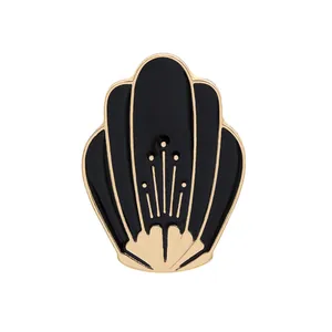 Close-up of enamel house brooch with gold trim and black fill in Art Deco style