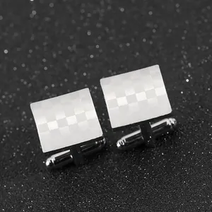 Detail of silver square cufflinks with laser-engraved checkered pattern for men