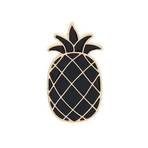 Detailed close-up of pineapple enamel pin in black and gold finish on white background