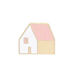 Minimalist house shaped enamel brooch with pink roof and gold plating on white background