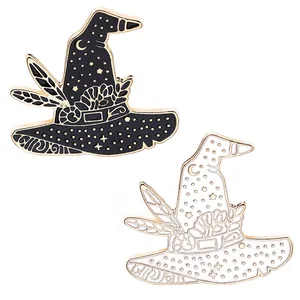 Detailed close-up of black and white enamel wizard hat pins with gold celestial patterns