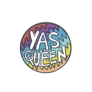 Detail of round enamel brooch with Yas Queen lettering and rainbow zigzag pattern