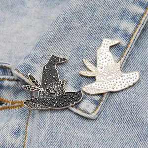 Set of black and white witch hat enamel pins with stars and moon on blue denim jacket