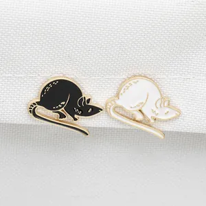 Cute black and white mouse enamel pins with gold metal trim on white textured fabric