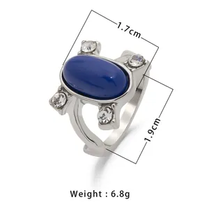 Anello vintage con pietra blu ovale e zirconi bianchi su base metallica argentata