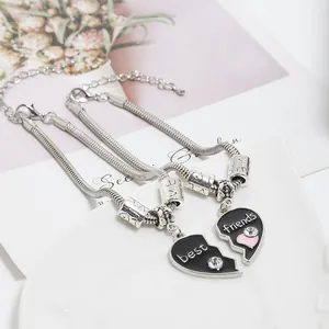 Detail of Best Friends puzzle heart charms with black drip oil finish and silver snake chain