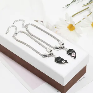 Detail of two-piece heart puzzle best friends necklaces with pink accents and silver snake chain