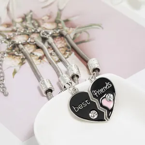 Detail of Best Friends heart puzzle necklace with black enamel and crystal inlay on tray