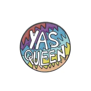 Rainbow enamel lapel pin with bold YAS QUEEN text and colorful wavy geometric pattern