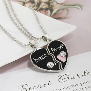 Close-up of Best Friends heart puzzle necklaces with black enamel and pink crystals