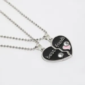 Detail of a two-piece heart puzzle necklace set featuring black drip oil and best friends text