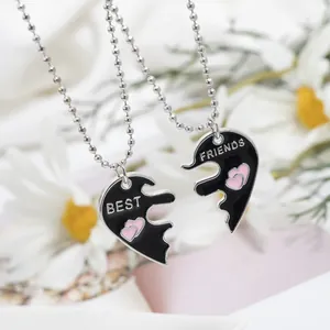 Détail de colliers Best Friends avec cœurs séparables en émail noir et rose