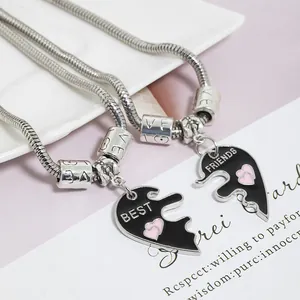 Vue détaillée des colliers Best Friends avec pendentifs en cœur émaillé noir et chaînes