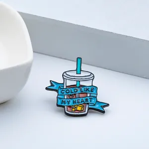 Detail der Emaille-Kaffeanstecknadel mit Cold Like My Heart Text und blauem Band