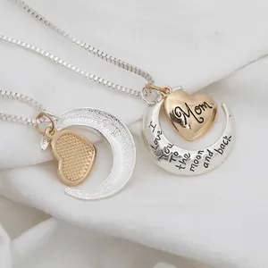 Detail of gold heart 'Mom' pendant and silver moon necklace with engraved message