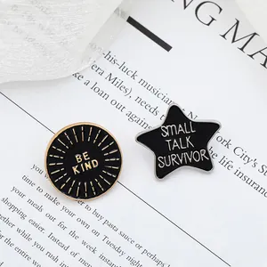 Set of enamel pins featuring Be Kind round badge and Small Talk Survivor star pin