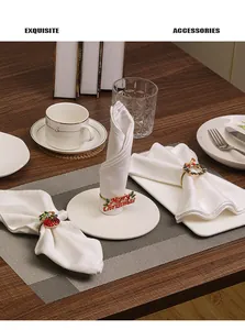 Close-up of golden Christmas napkin rings with Merry Christmas lettering and festive wreaths