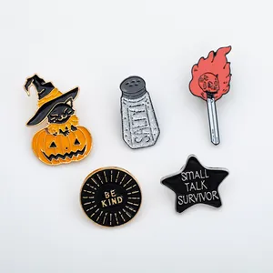 Detailed close-up of 5 enamel pins featuring a pumpkin, salt shaker, and slogan badges