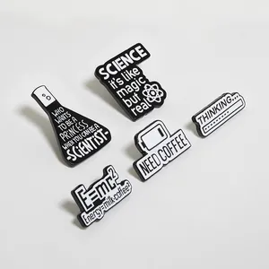 Close-up of enamel pins featuring science themes, coffee icons, and E=mc2 formula