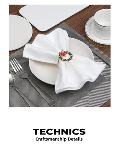 Detail of Christmas wreath napkin ring with red bow and gold bells on white linen
