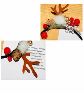 Detalle de diadema de cuernos de reno navideño con bayas rojas y piñas nevadas