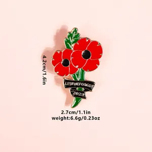 Detail of red enamel poppy brooch with Lest We Forget ribbon and 2023 engraving